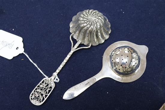A Chinese silver sugar bowl and two tea strainers.